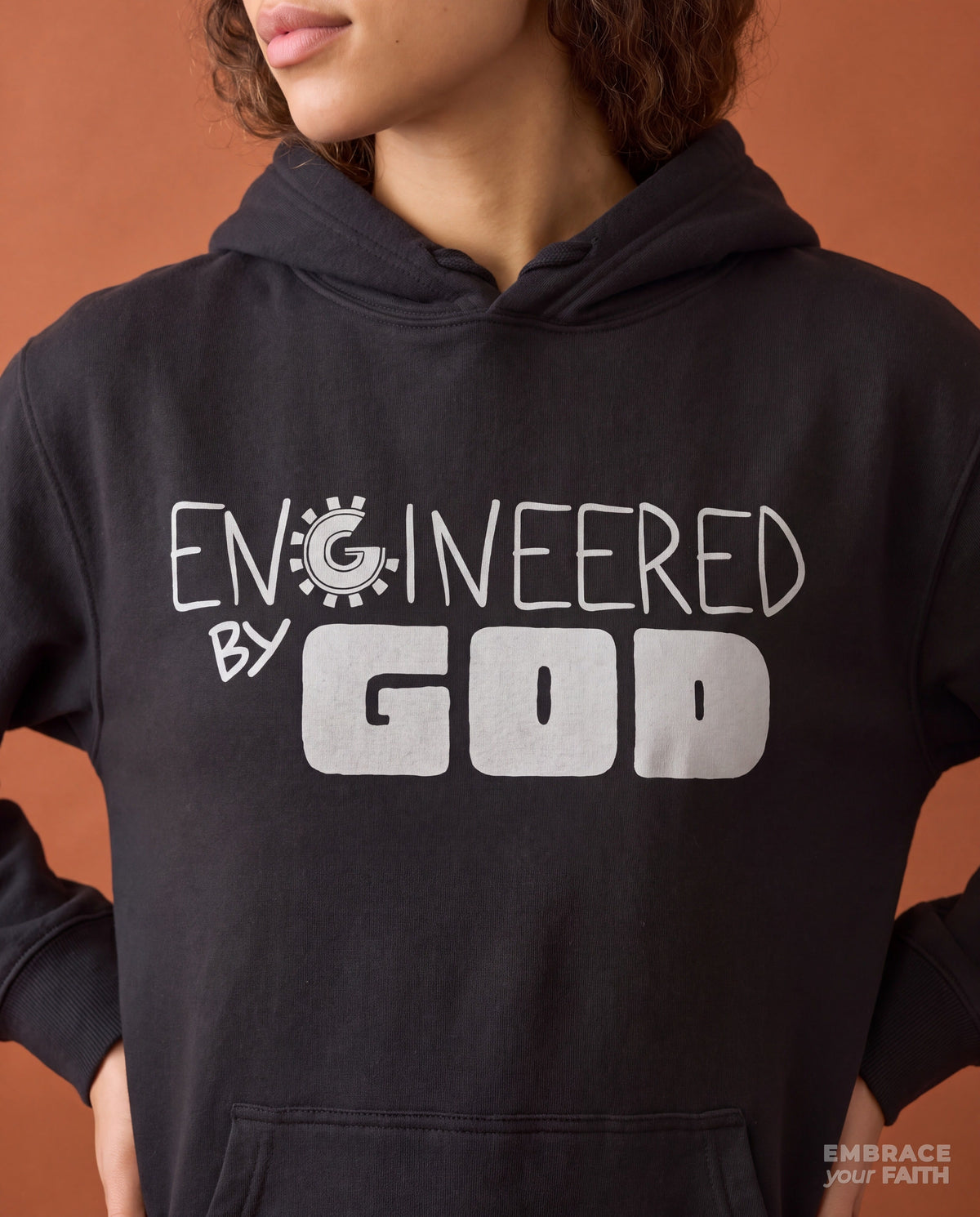 Close-up of the print on the Engineered By God Classic Unisex Hoodie in Vintage Black