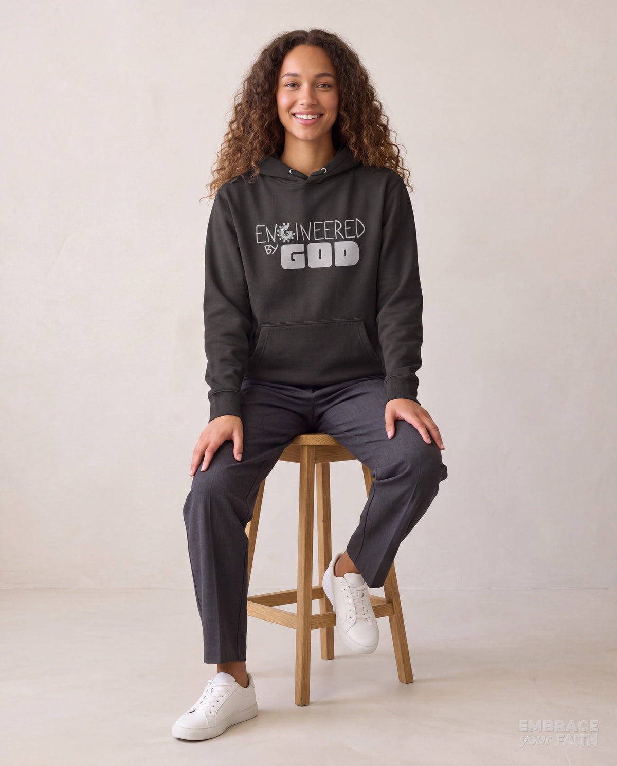 EYF model wearing the Engineered By God Classic Unisex Hoodie in Vintage Black